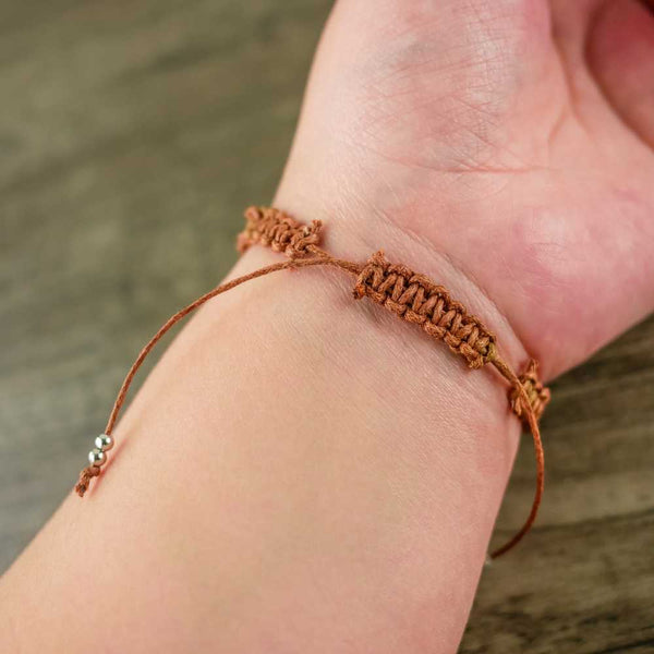 braço com pulseira de fio de algodão encerado