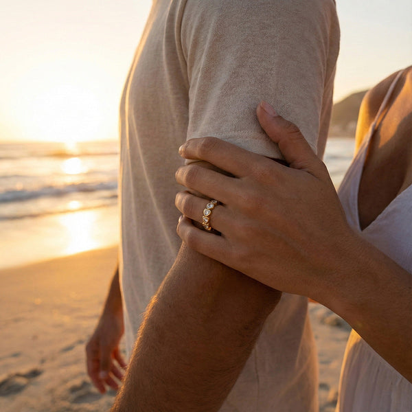 Um casal na praia. A mulher está a usar um anel coração elegante.