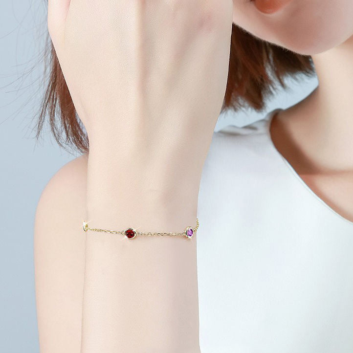 Uma Menina com Pulseira com Pedras Coloridas - Aço Inox Dourado