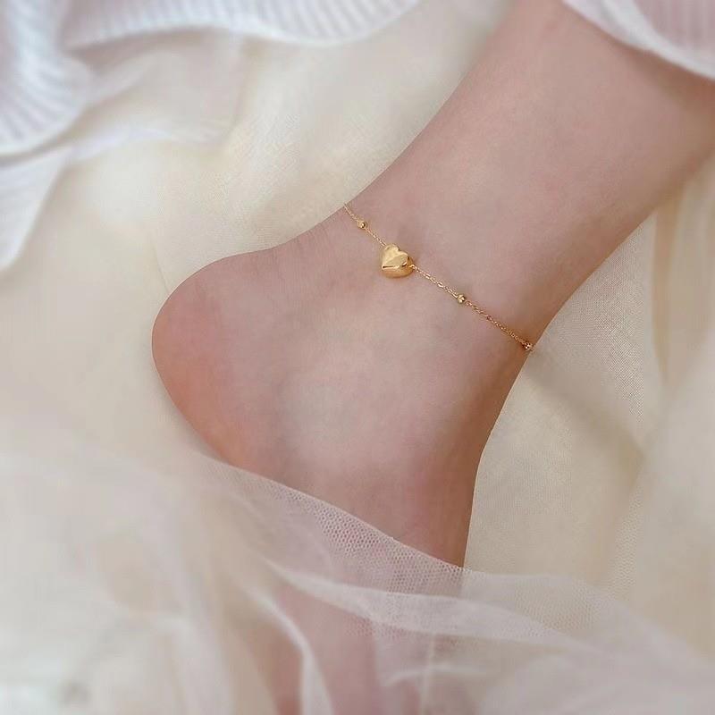 Um pé com pulseira de pé SL1082 em aço inox dourado